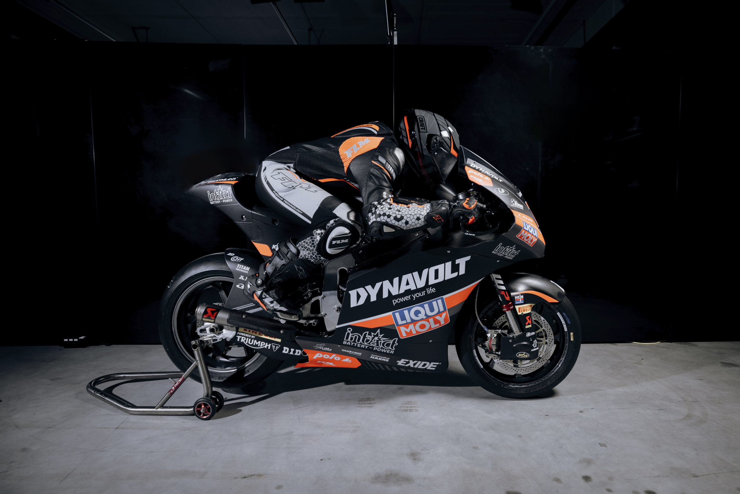 Motorradrennfahrer in kompletter schwarzer Lederkombi mit FLM-Branding verlässt die Boxengasse auf einer Yamaha R1 Rennmaschine
