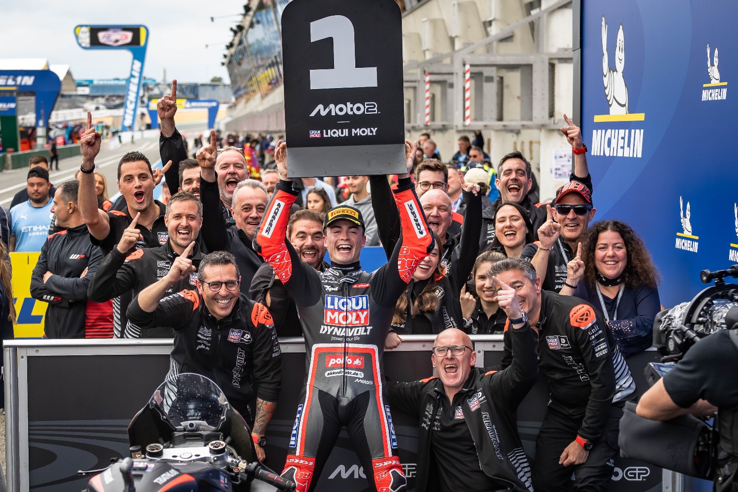 Motorradrennfahrer in kompletter schwarzer Lederkombi mit FLM-Branding verlässt die Boxengasse auf einer Yamaha R1 Rennmaschine